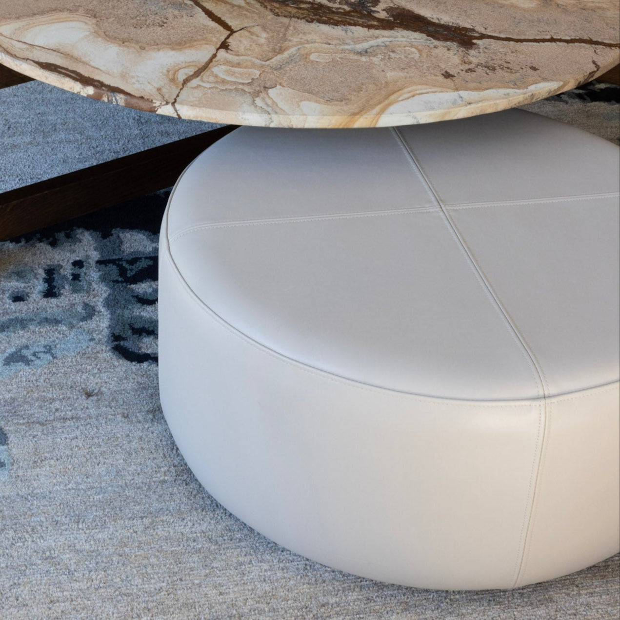 Round wooden coffee table with a natural finish in a living room setting.