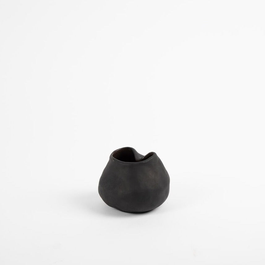 Gaia vase Small. The Gaia vases have a matte finish with a glossed glaze inside. Its unbalanced shape makes for unique curves from all angles. Can be used to display flowers or on its own.  Available in three sizes in black.